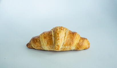 Freshly baked croissant on colored background