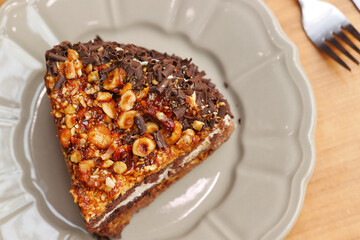 chocolate, nut and cream cake on a plate on table 