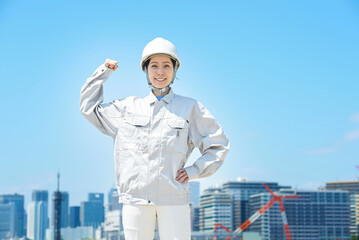 ポジティブなポーズをする作業着姿の女性