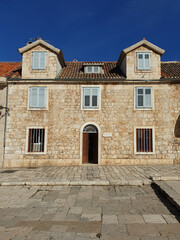 Fototapeta na wymiar historical building with stone wall located in main town square at Hvar, Croatia