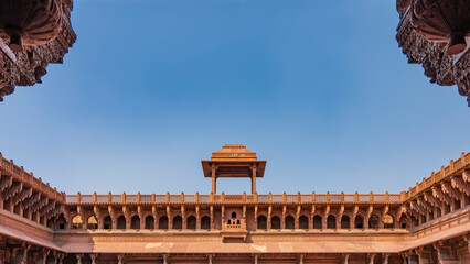Obraz premium Details of the architecture of the Jahangir Mahal Palace. The upper part of the building with galleries, arches. There is a pavilion with a dome on the roof. Lattice fence around the perimeter. Agra