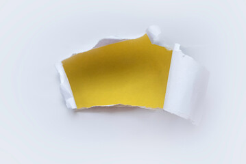 A hole of paper ripped and torn. Reveal a yellow wall behind. Backdrop or background.