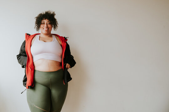 portrait of a plus size afro indigenous person wearing workout gear and smiling