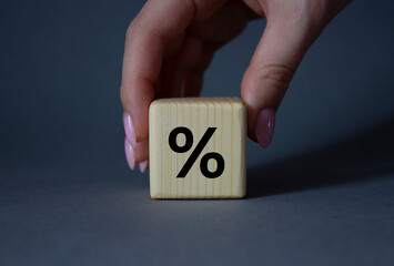 Percentage sign symbol. Percentage sign on wooden cubes. Businessman hand. Beautiful grey background. Business and Percentage sign concept. Copy space.
