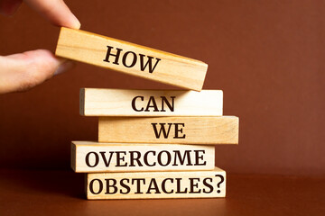 Wooden blocks with words 'How can we overcome obstacles?'. Motivation Quote