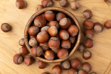 Hazelnuts in a bowl on wooden background. Top view