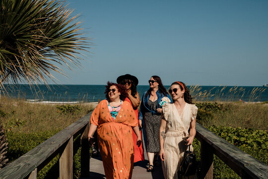 4 friends walk on boardwalk
