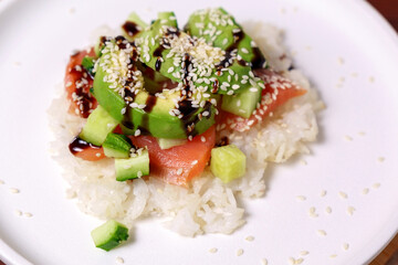 Sushi Waffle is crispy rice, made in a waffle maker, topped with shoyu salmon, crunchy cucumber