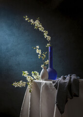 Still life with branches of cherry blossoms on a blue background