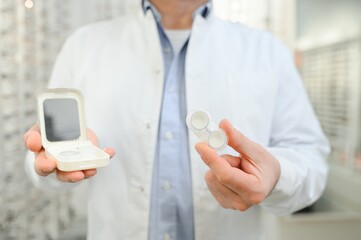 Doctor holds in his hand container with soft contact lenses for single use. Ophthalmologist prescribes use of one-day contact lenses for vision correction. Myopia and eyesight problem concept.