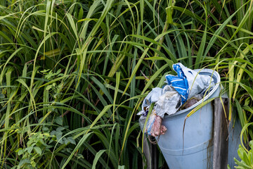 Fototapeta premium Garbage on tropical beach. Old tire and construction debris on seashore sand. Tropical island environment pollution. Trash thrown by seaside. Tropical beach tourism industry impact. Ecological problem