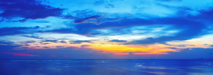 Fototapeta premium Beautiful sea sunset panoramic landscape, ocean sunrise panorama, tropical island beach dawn seascape, blue water, colorful red pink orange yellow sky clouds, sun reflection, summer holidays, vacation
