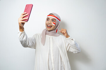 Portrait of Young Asian Muslim Women celebrate Indonesian independence day using smartphones