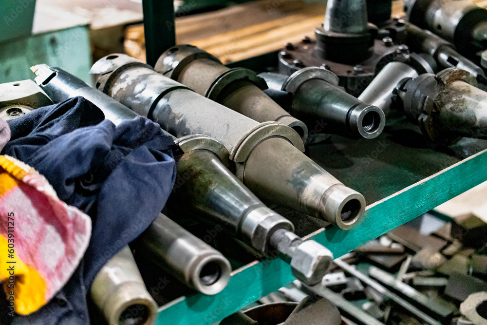 Poster a set of milling cutters on a rack near a lathe. metalworking cutting mills for cnc machines. indust