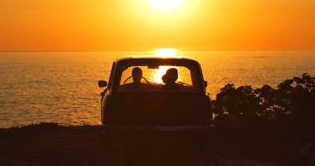 Beach, silhouette and people in car at sunset for freedom, travel or road trip together. Dark,...
