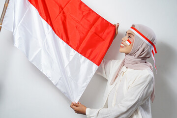 Portrait of Young Asian Muslim Women celebrate Indonesian independence day holding red and white...