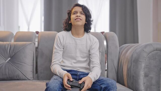 Competitive Indian teenager boy playing video games