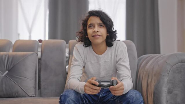 Happy Indian kid boy playing video games