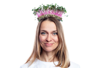 Smiling young woman in a white t-shirt with radish microgreens on her head in the form of a crown. Eco products, vitamins and health. Isolated on white background. Close-up.