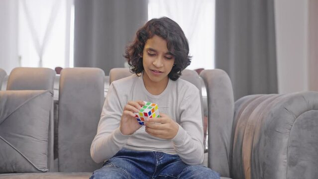 Angry Indian kid boy gets frustrated unable to solve Rubik's cube