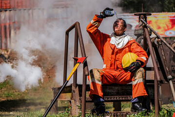 In the midst of the scorching outdoor heat a professional firefighter finds respite by sitting down...