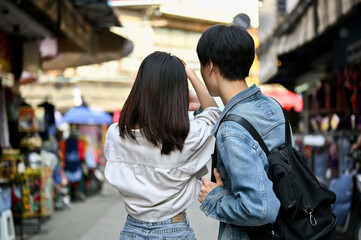 A tourist couple enjoys taking photos and sightseeing the Chiang Mai old town market