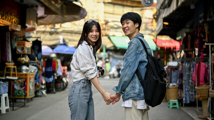 A tourist couple holding hands while sightseeing the Chiang Mai old town