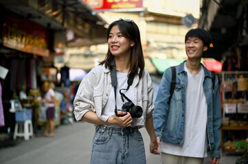 A female enjoys taking photos and sightseeing the old town market with her boyfriend