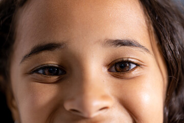 Close up portrait of happy biracial girl patient smiling in corridor at hospital