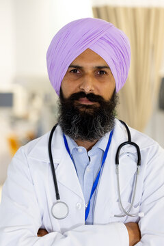 Portrait of happy sikh male doctor wearing turban and stethoscope smiling at hospital