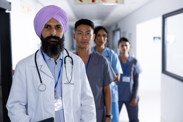 Portrait of diverse male and female doctors standing in corridor at hospital
