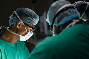 Diverse surgeons operating on patient in operating theatre at hospital