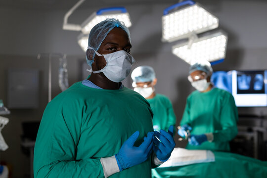 Portrait of african american male surgeon during surgery in operating theatre