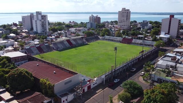 Aerial drone forward moving shot flying high up over an empty football field of Club Deportivo Guaraní Antonio Franco in Argentina on a sunny day