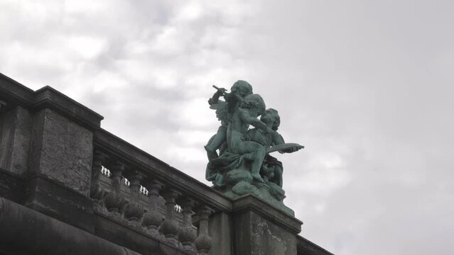 Cherub Sculpture (Music) Against Cloudy Sky Outside The Royal Palace In Stockholm, Sweden. low angle