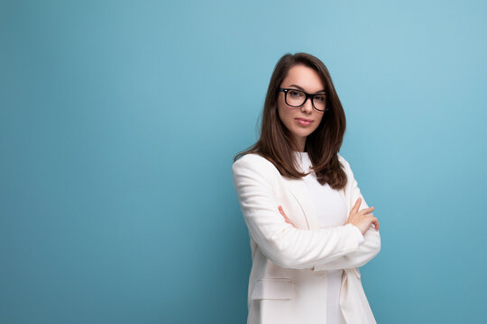 Confident Brunette Woman In White Business Dress On Studio Background