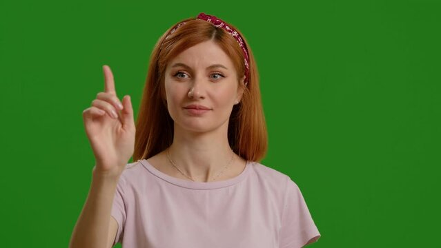 Beautiful young woman using interactive touch screen with various gestures isolated green screen background. Casual woman using touch screen moving fingers.