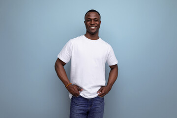 handsome young african man in white t-shirt on blue background with copy space