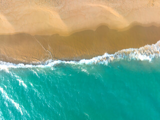 Ocean waves on the beach as a background. Beautiful natural summer vacation holidays background. Aerial top down view of beach and sea with blue water waves  © Hand Robot