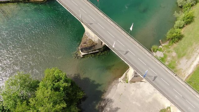 Scenic moment of a drone starting its descent next to a bridge bearing the European flag crossed by a child along the security barrier and vehicles on the road