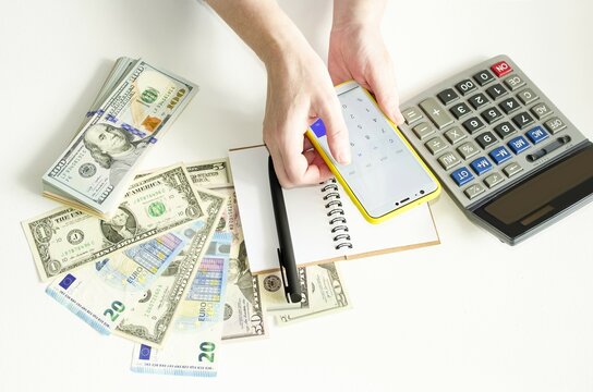 Payment of bills by phone online, financial transactions, payment of utilities.  On a white background, money, currency, telephone calculator, record keeping.  View from above.