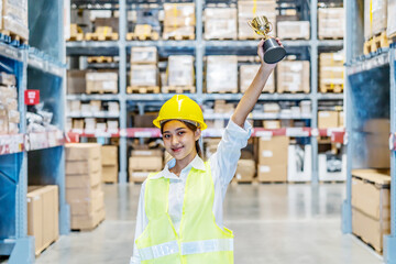 Happy asian young woman warehouse worker holding a trophy after being selected as an outstanding employee, business success
