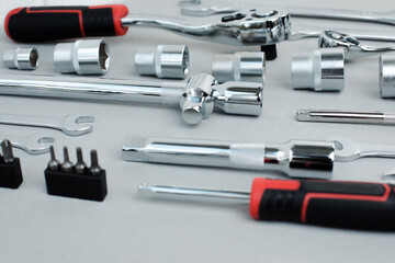 Fototapeta premium A set of working tools, a hammer, a screwdriver, sockets for an answer on a gray concrete background. Front view