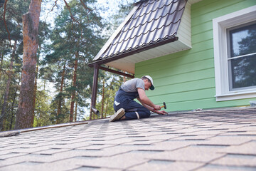 A worker repairs a soft roof. Renovation of a country house