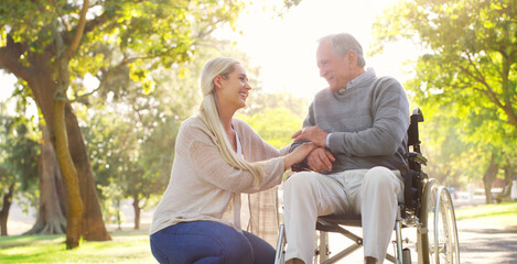 Happy, talking and man in wheelchair with a woman in nature for care and support. Holding hands,...