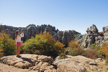 Girl taking photograph of rock formation in El Torcal de Antequera, Spain