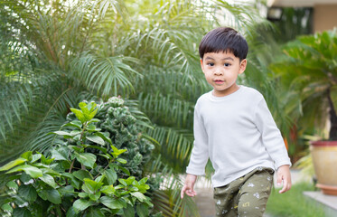 Portrait of a happy little Asian boy in the park. Active kid playing outdoors.