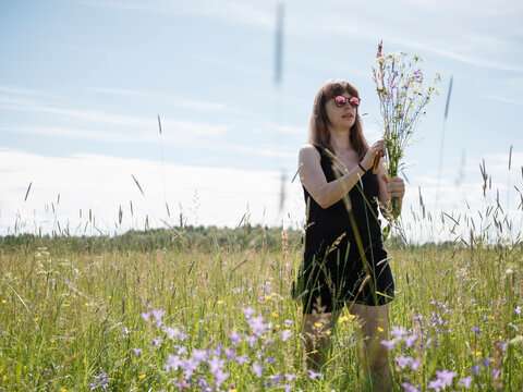 Young woman in meadow with flowers