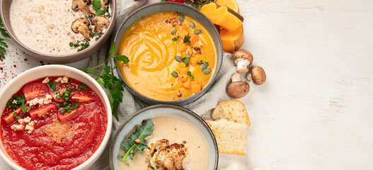Composition with various soups, ingredients and space for text on white background. Healthy food.