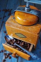 Grains of fresh fragrant coffee and an old vintage coffee grinder.
